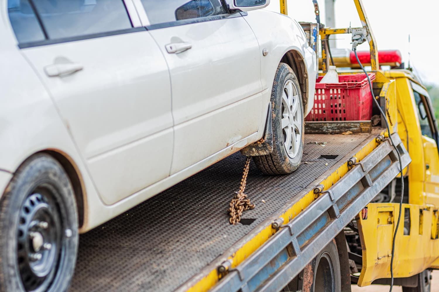 Vehicle wheel chained down on a flatbed tow truck