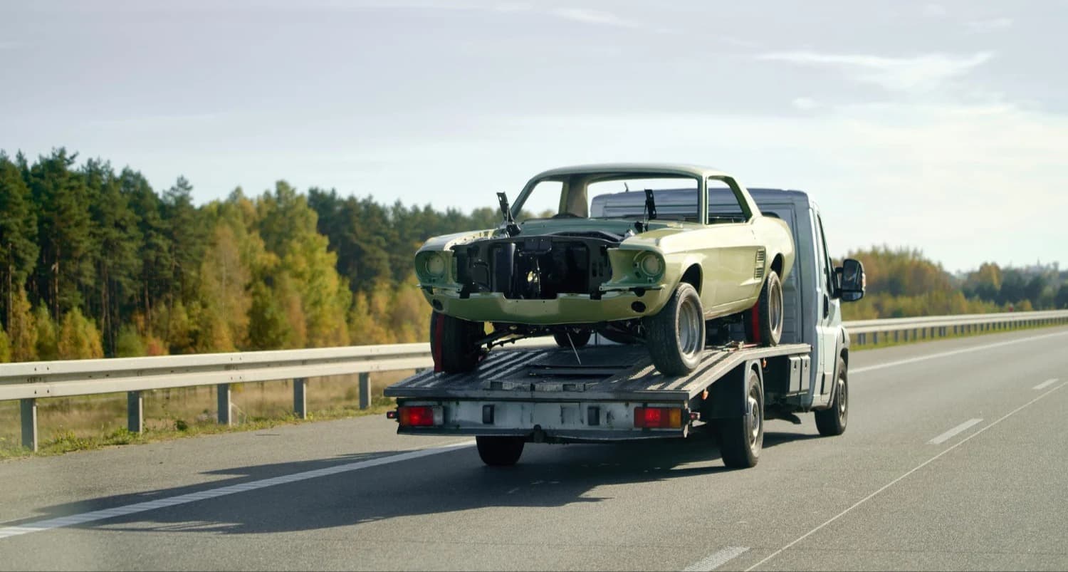 Flatbed tow truck hauling a classic muscle car