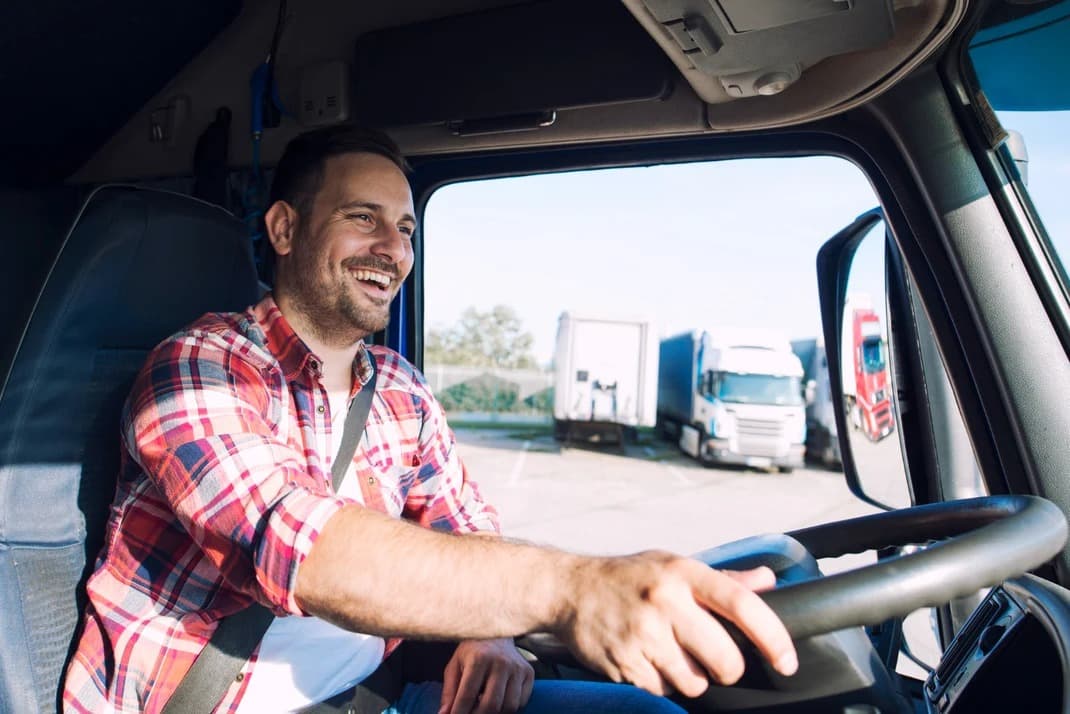 Smiling tow truck driver in the cab
